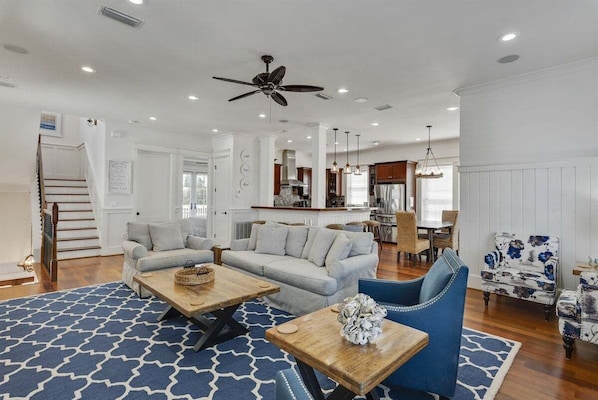 A spacious living room with a sofa, coffee table, and blue patterned rug.