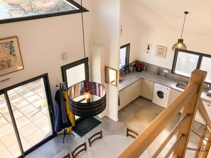 Een moderne keuken met een eethoek, een wasmachine en een eettafel met stoelen.