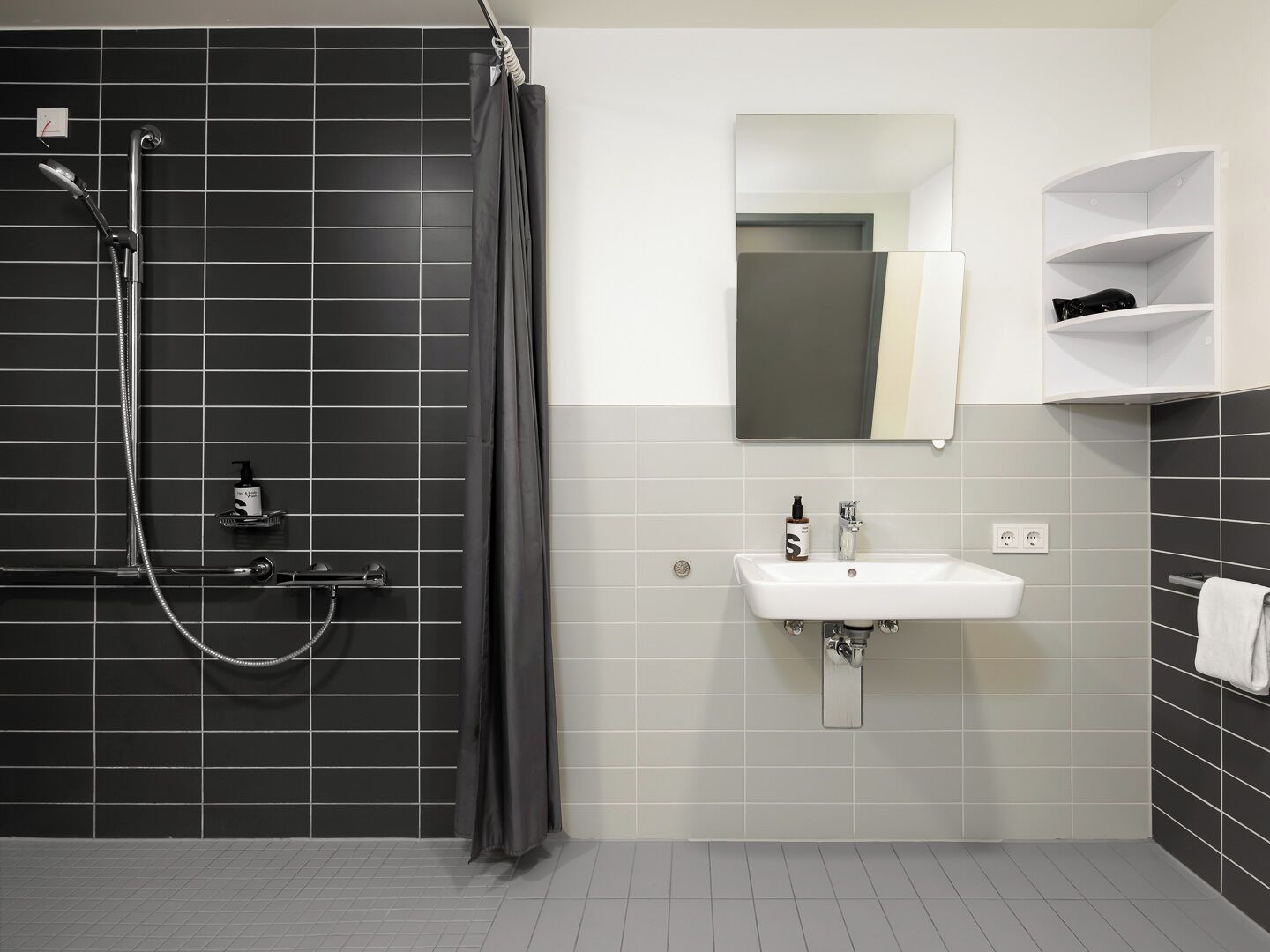A modern bathroom with a shower, sink, and mirror.
