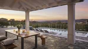 A covered outdoor area with a pool, lounge chairs, and a table set for dining. - Lovely Villa Arman with a pool and a jacuzzi (Vizinada)