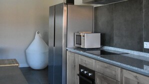 Una cocina moderna con refrigerador, microondas y lavavajillas de acero inoxidable.
