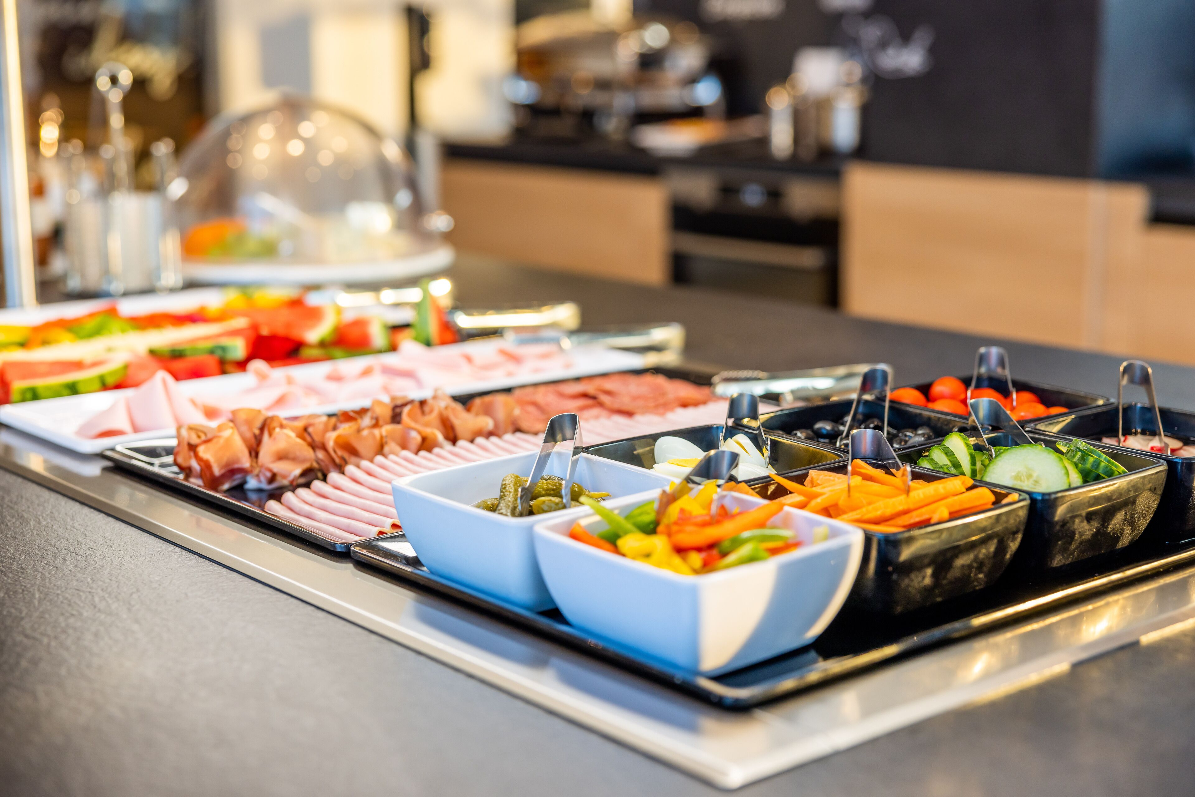 A buffet with various food options including meats, vegetables, and fruits.