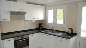 A modern kitchen with white cabinets, a black countertop, stainless steel appliances, and a window with a view of greenery. - PRIVATE Villa with Pool/WIFI/PARKING - Villa Alba, Villa Alba In L'Escala - $ Bedrooms, Pool, WIFI (L'Escala)