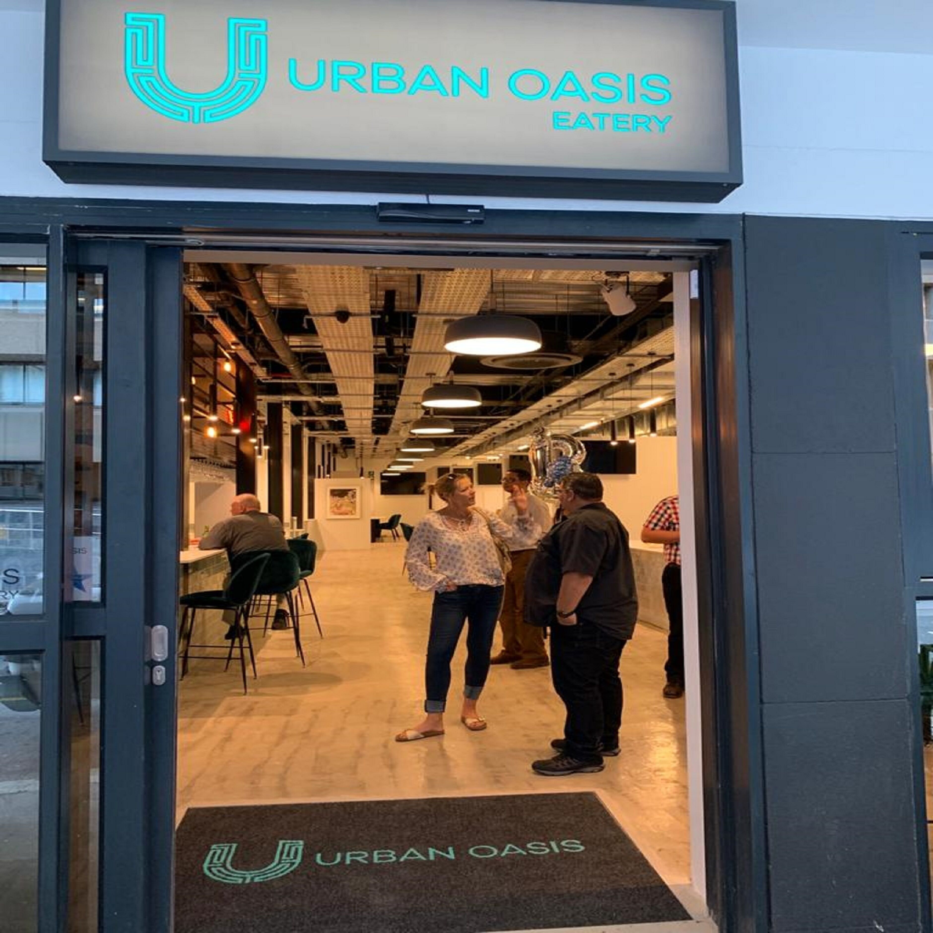 The entrance to Urban Oasis Eatery with a modern interior visible through the doorway.