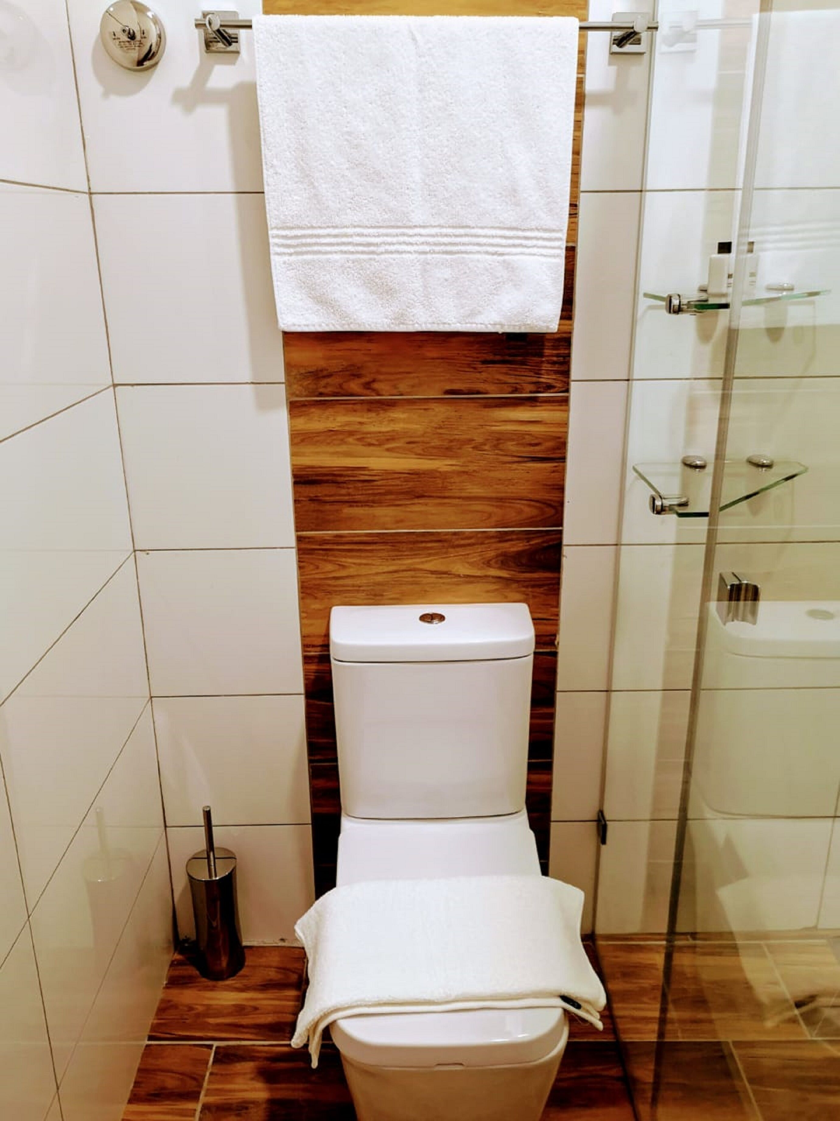 Un baño con inodoro, bidé y cabina de ducha de vidrio.