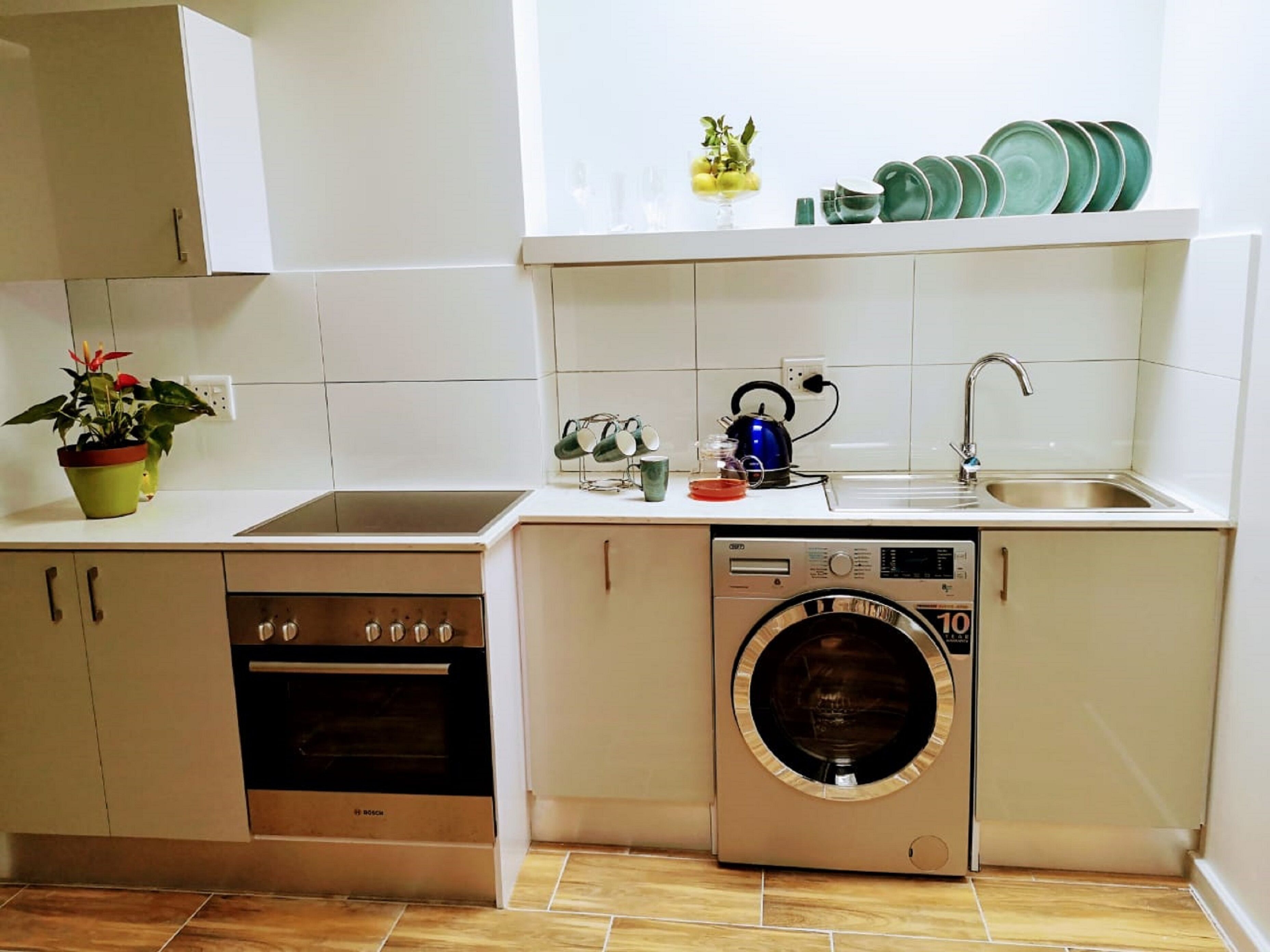 A compact kitchen with a dishwasher, oven, and washing machine.