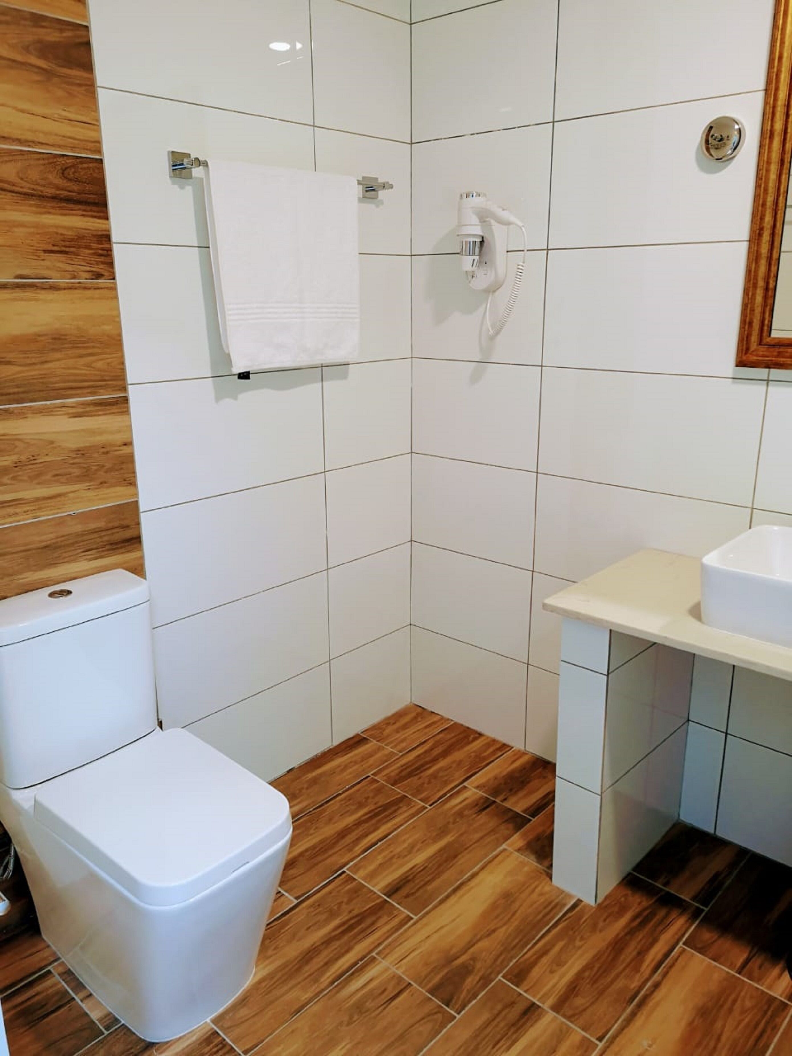 A bathroom with a toilet, sink, and shower.