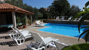 A swimming pool with white lounge chairs and a pergola. - Apartment with shared pool (Sveti Vid Miholjice)