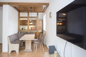 Un'area pranzo moderna con tavolo in legno e sedute imbottite.
