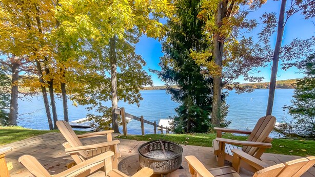 Terraza con sillas Adirondack y un brasero con vista al lago.