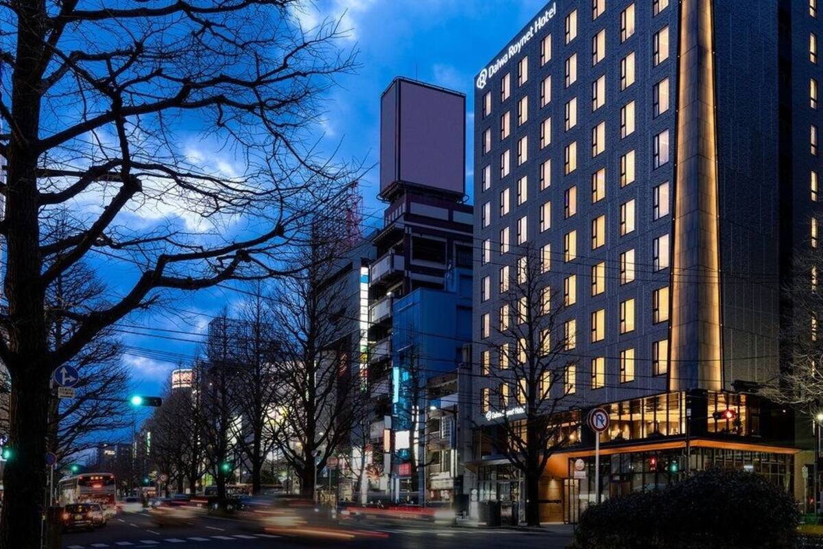 Un hotel de varios pisos con fachada moderna, ventanas amplias y una entrada destacada.