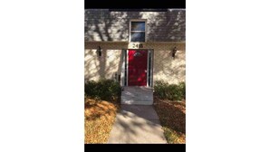 A building with a red door and the number 2416 above it.