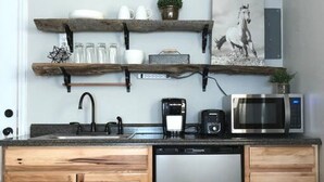 A kitchen with wooden cabinets, a dishwasher, a coffee maker, and a microwave.