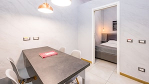 A modern room with a dining table, chairs, a bed, and pendant lights. - Baubo - S. G. Armeno by Napoliapartments (Naples)