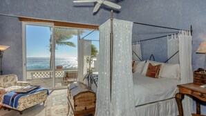 A bedroom with a four-poster bed, a ceiling fan, and a view of the ocean. - Beachfront 5 BR Villas del Mar 461 fts. Private Pool, Hot Tub, WiFi + Much More! (Los Cabos)