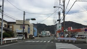 Una intersección urbana con semáforos, paso de peatones y edificios comerciales.
