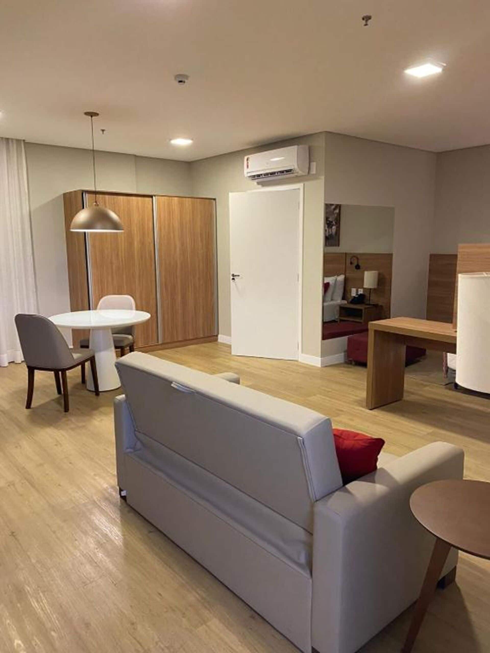 A modern, well-lit living area with a sofa, dining table, and chairs.