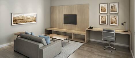 A modern living room with a grey sofa, a wooden desk, and a mounted TV.