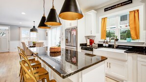 A modern kitchen with a central island, pendant lighting, and a view of the outdoors. - Incline Heights Haven - St Elmo District,  Chattanooga (Chattanooga)