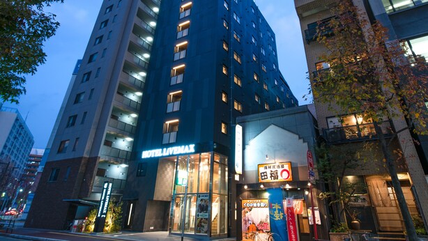 A modern hotel with a prominent 'HOTEL LAVEMAX' sign, multiple floors, and a glass facade. - Hotel Livemax Hakata-ekimae (Fukuoka)