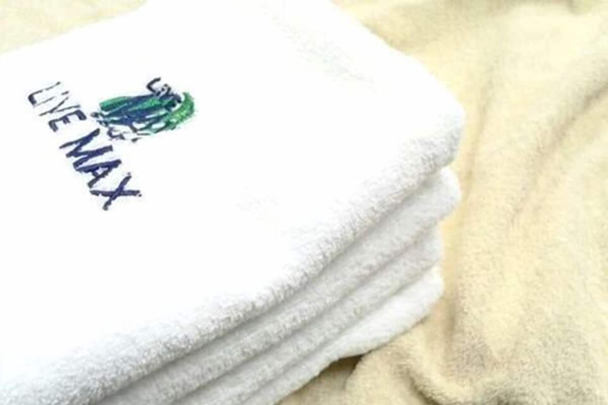 Uma pilha de toalhas brancas, com um logotipo e texto em uma delas.