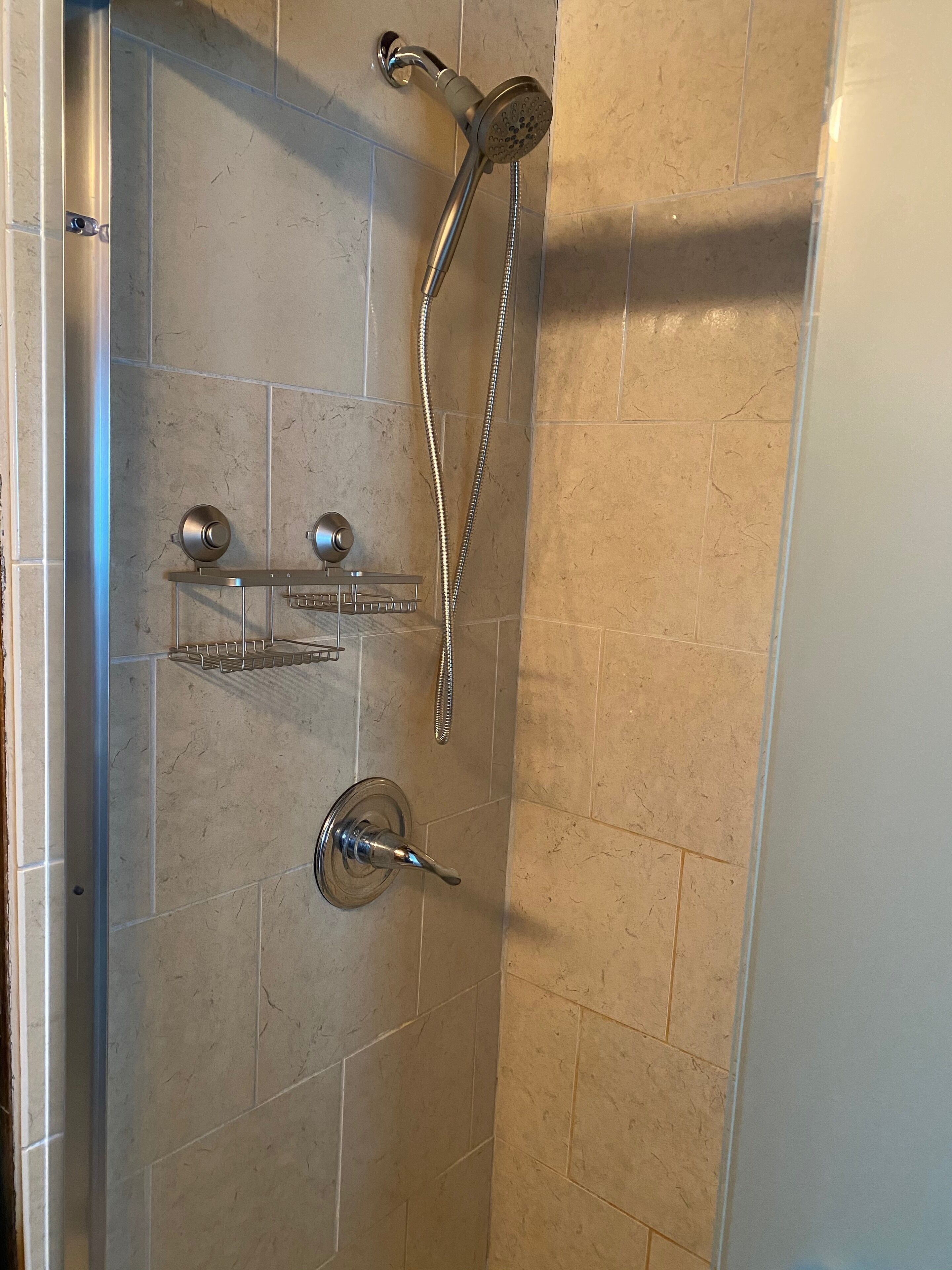 Ducha con cabezal de ducha de mano y grifo empotrado.