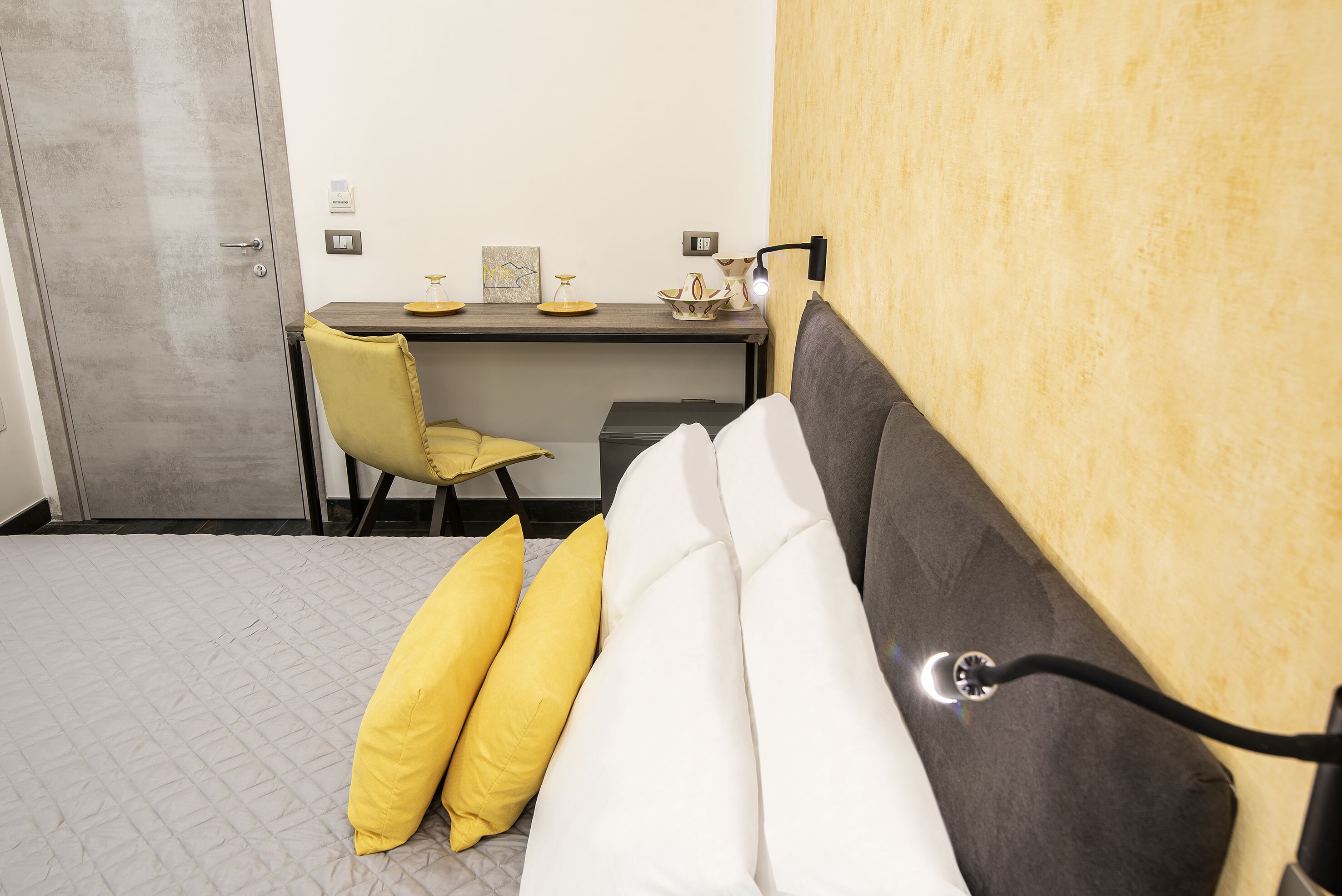 A bedroom with a bed, a desk, and a chair.
