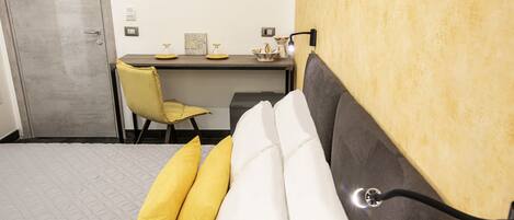 A bedroom with a bed, a desk, and a chair.