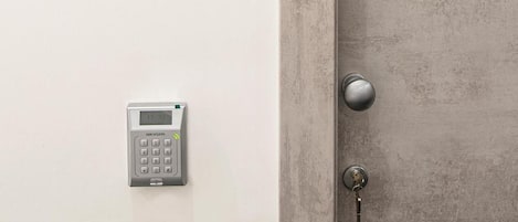 A door with a number plate and a keypad lock.