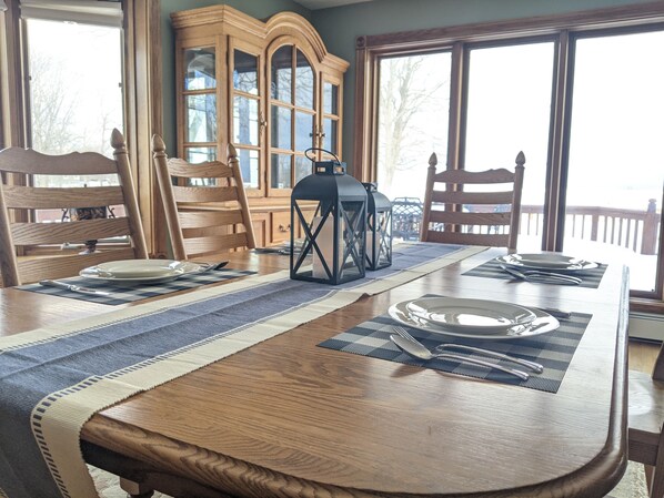 A dining table set with plates, cutlery, and a lantern. - Lake front house with Pool and hot tub and game room (Brewerton)