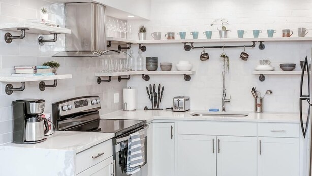 A modern kitchen with white cabinets, stainless steel appliances, and a variety of kitchenware on shelves. - Renovated 2story(7C) OSU/ExpoCenter/Central ❤NearEVERYTHING (Columbus)