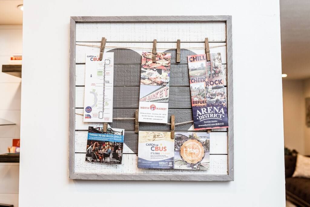 A bulletin board with various printed materials clipped to it.