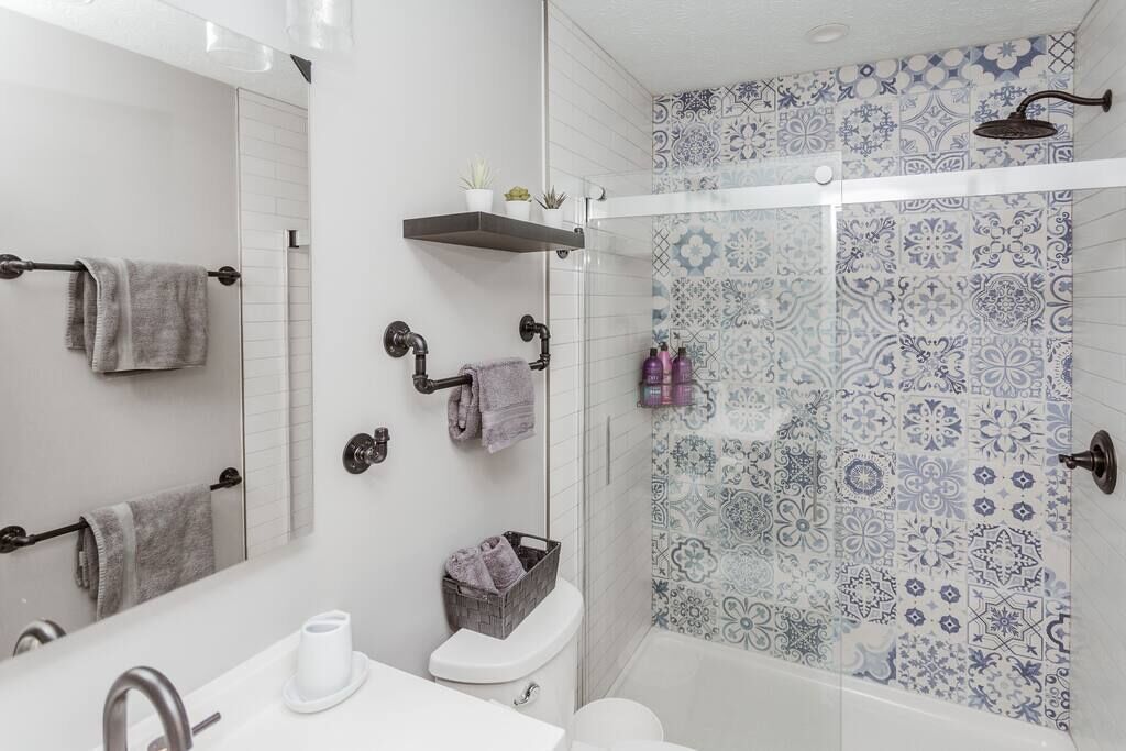 Une salle de bain moderne avec une douche à parois de verre, un lavabo blanc et des toilettes.