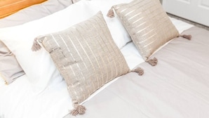 A bed with two beige pillows and a wooden headboard.