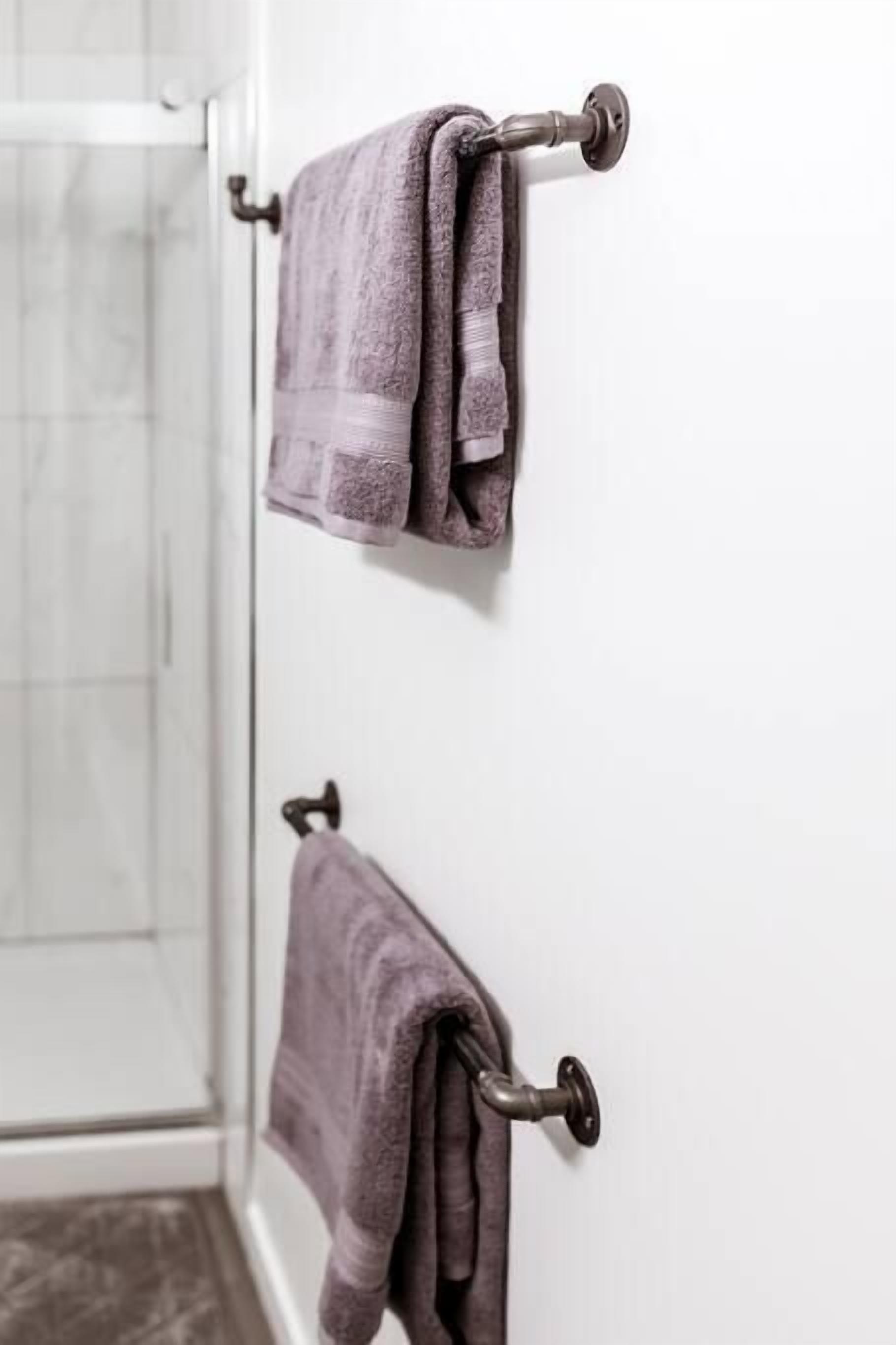 A bathroom with two towels hanging on towel racks.