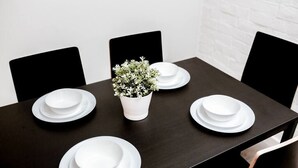A dining table with white plates and a small potted plant in the center. - Newly Renovated (6A) OSU/Central ❤NearEVERYTHING (Columbus)