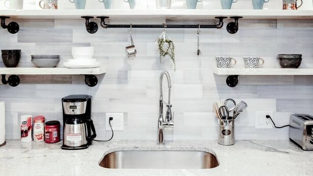 A kitchen with a stainless steel sink, a coffee maker, and various kitchen utensils on the countertop. - Newly Renovated (6A) OSU/Central ❤NearEVERYTHING (Columbus)