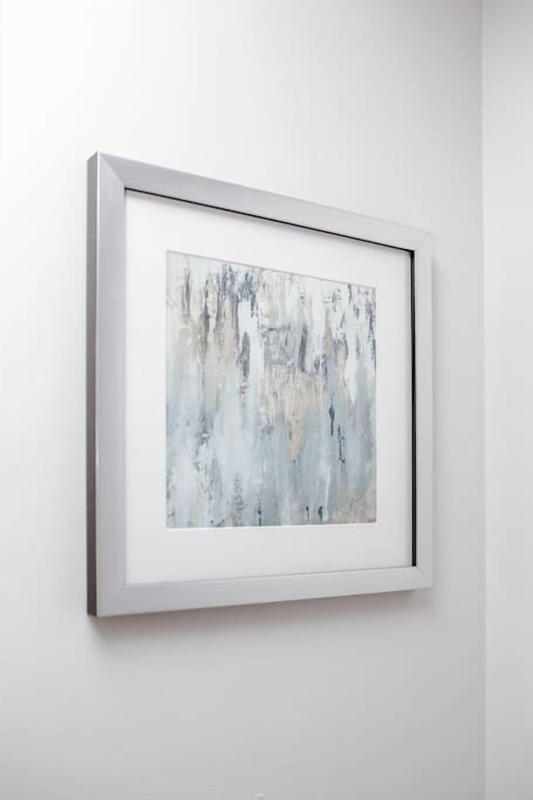 A framed abstract painting on a white wall.