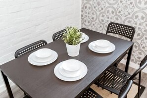 Enjoy meals in this dining area with a table for four, a potted plant, and comfortable black chairs.
