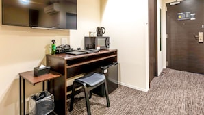 A hotel room with a desk, chair, trash bin, and a flat-screen TV mounted on the wall. - HOTEL LiVEMAX OKAZAKI (Okazaki)
