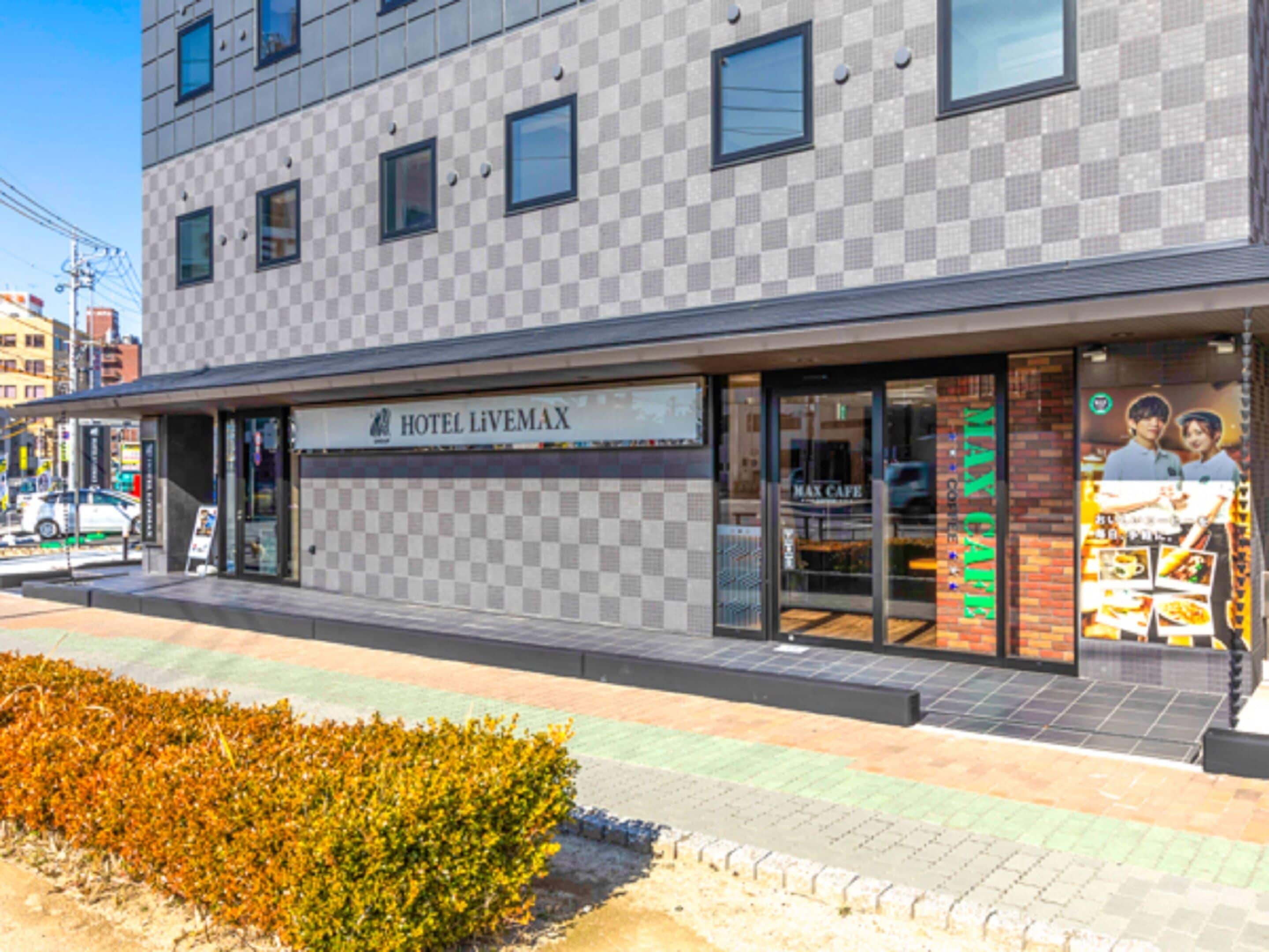 Un hotel con fachada a cuadros, una entrada visible y un letrero que dice 'HOTEL LIVEMAX'.