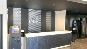 A hotel reception desk with a modern design, including a textured wall and a digital kiosk. - Hotel LiveMax Nagoya-Shinkansenguchi (Nagoya)