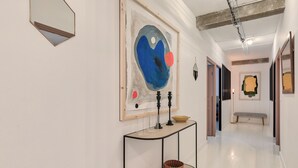 Ein Flur mit einer Konsole, Körben und abstrakter Kunst.