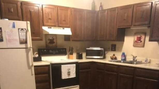 A kitchen with wooden cabinets, a white refrigerator, a microwave, and a stove. - HCHideaway-Quiet, Cottagelike!  Pet Friendly!  Queen bed! (Aberdeen)