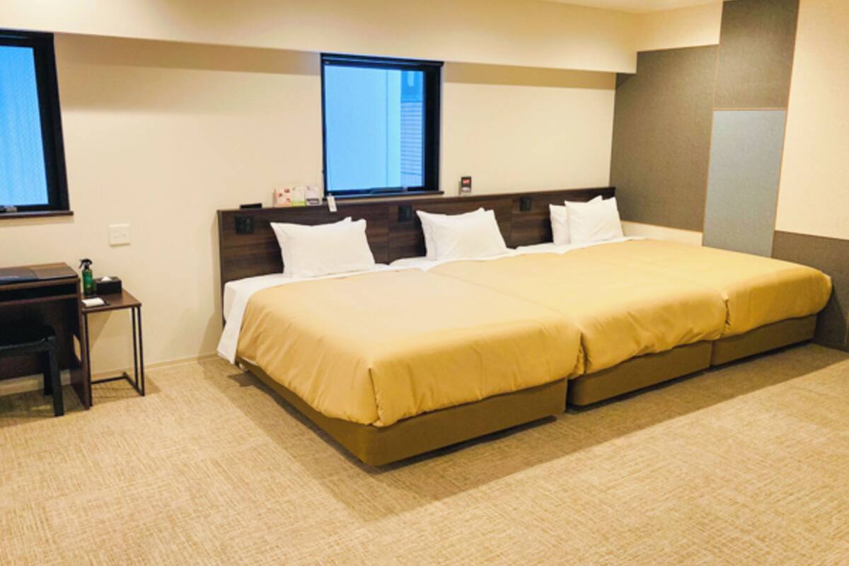 Ein Hotelzimmer mit einem großen Bett, einem Schreibtisch und einem Fenster.