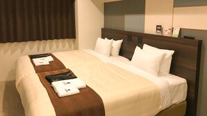 Une chambre d’hôtel avec un grand lit, une tête de lit dotée de commandes intégrées, une fenêtre avec des rideaux et un climatiseur fixé au mur.