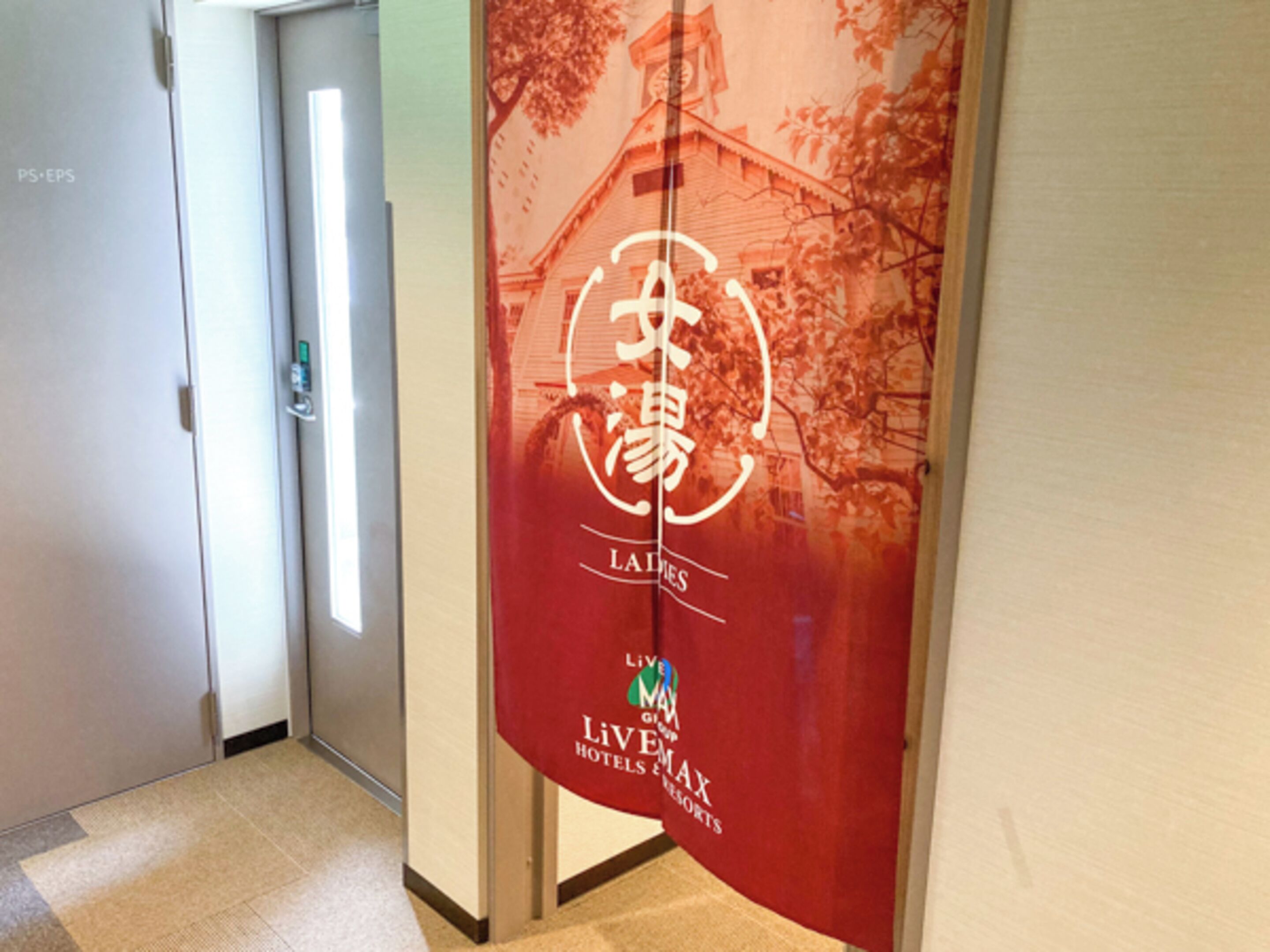Un pasillo con un cartel rojo que muestra un edificio y los textos "Lakes" y "LiVEMAX Hotels & Resorts".
