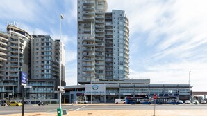 Ein modernes Hochhaus-Hotel mit mehreren Balkonen und einem markanten Eingang.