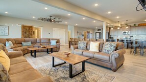 A spacious living room with a large sectional sofa, a coffee table, and a dining area with wooden chairs. - Stay awhile and prolong your smile (Branson)