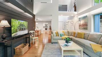 A spacious living room with a fireplace, a sofa, and a television.